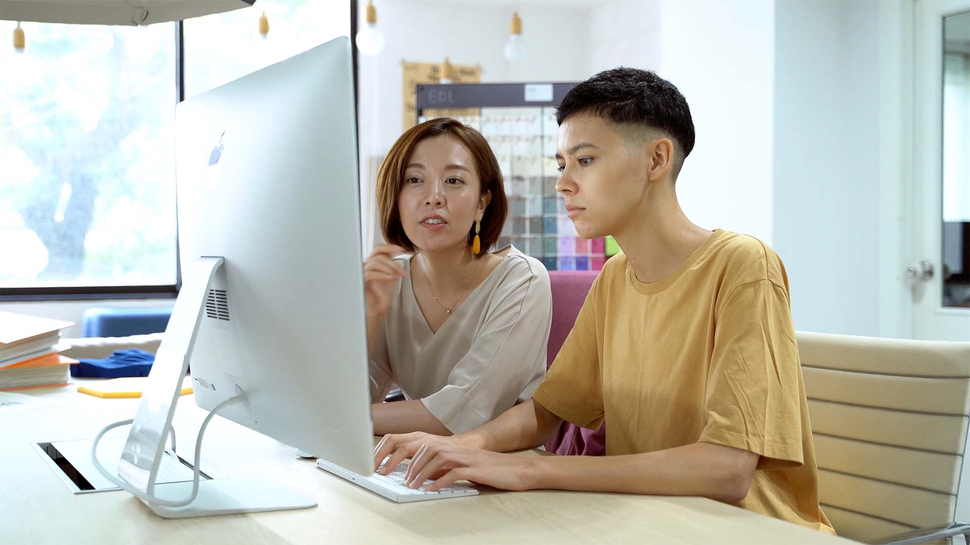 Two people working at a computer.