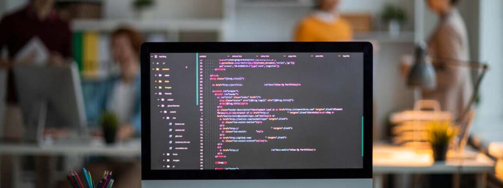 STUDIO FIVE - Benefits of Custom Web Development - Computer screen displaying code in office.