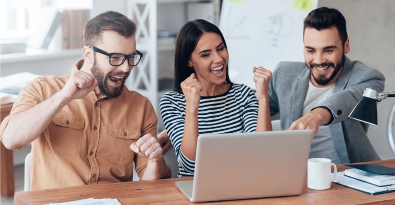 STUDIO FIVE - How to Increase Website Engagement: An excited team celebrating at a laptop.