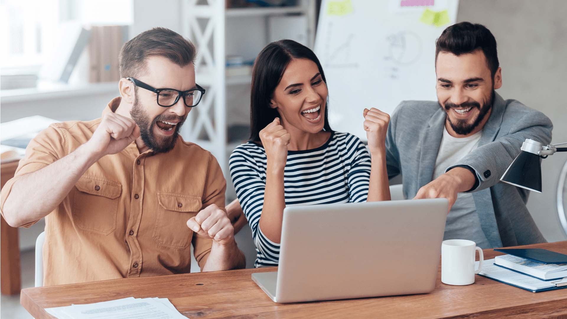 STUDIO FIVE - How to Increase Website Engagement: An excited team celebrating at a laptop.